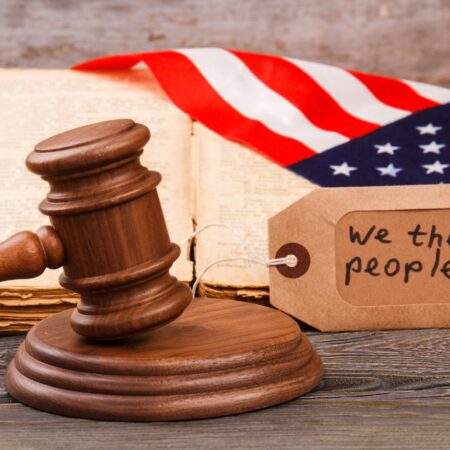 American court concept. We are the people slogan on the label. Brown wooden gavel.