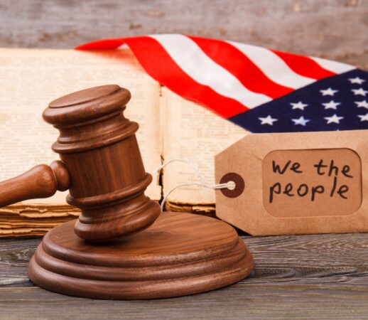 American court concept. We are the people slogan on the label. Brown wooden gavel.